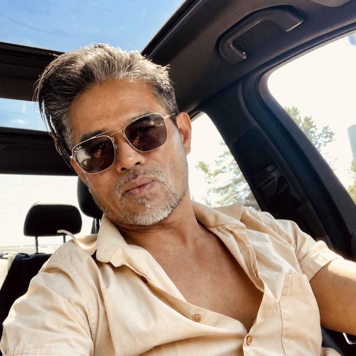 Vincent Nguyen wearing sunglasses in a sunlit car