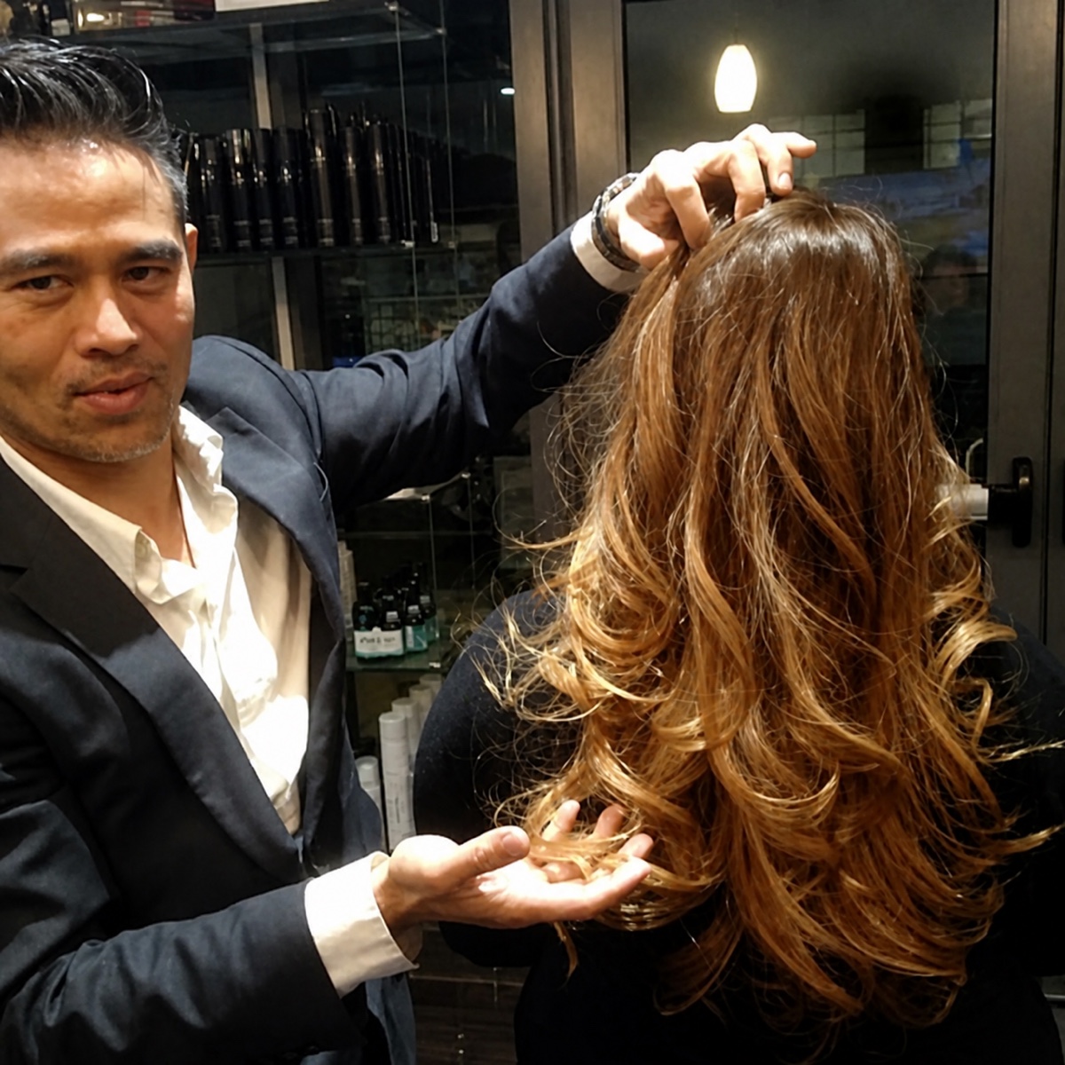 Vincent Nguyen presenting a client's finished long layered hairstyle