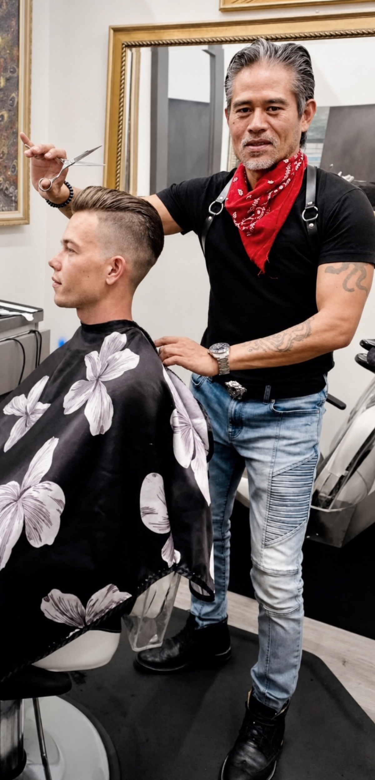 Vincent Nguyen holding scissors while finishing a client's sculpted fade