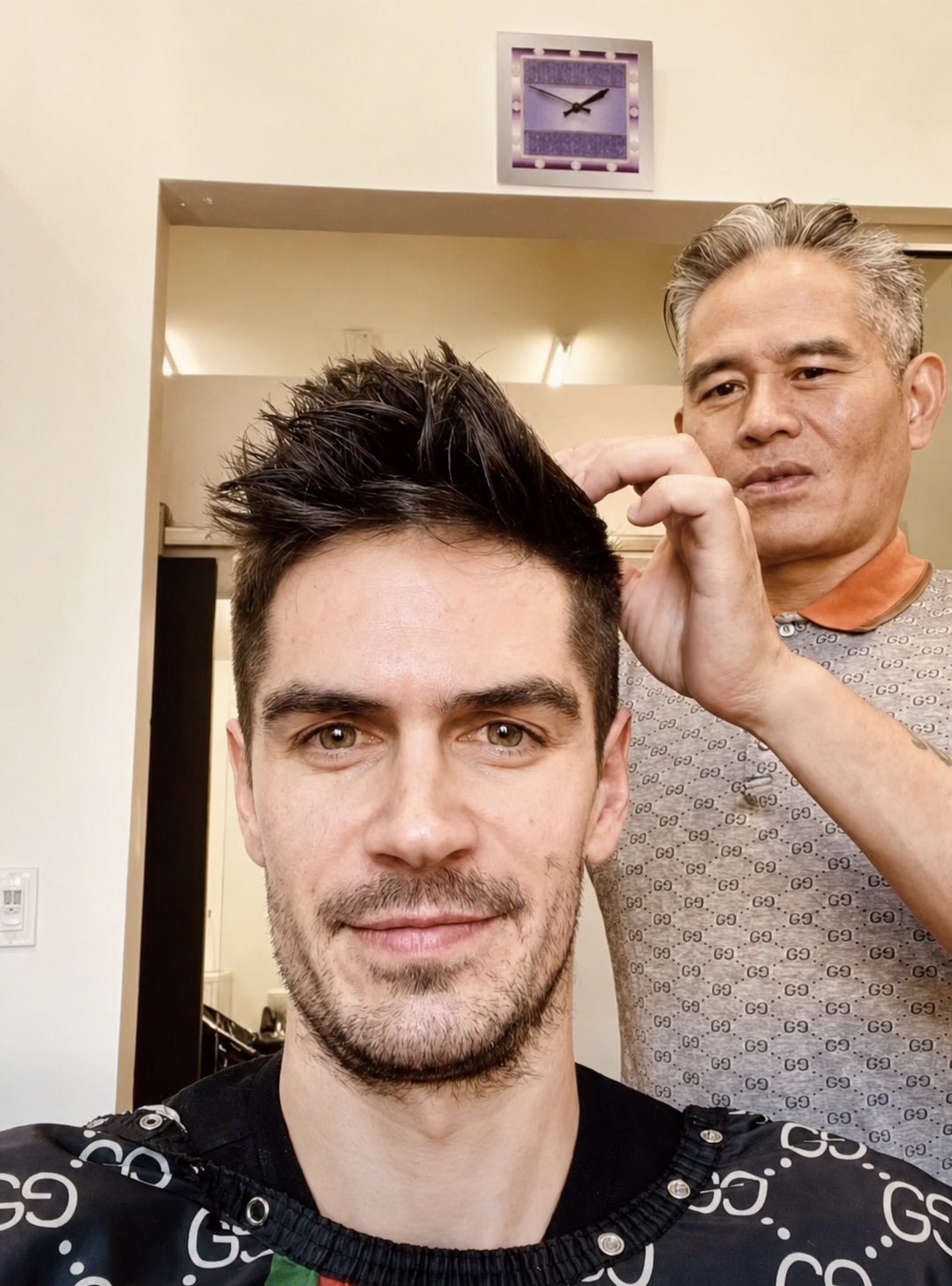 Vincent Nguyen refining the textured top of a client's finished short haircut